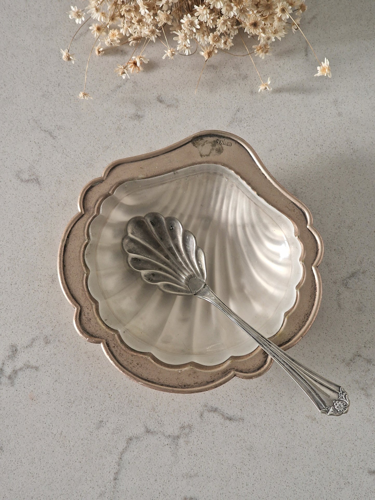 Metallinen simpukka-astia ja tarjoilulusikka